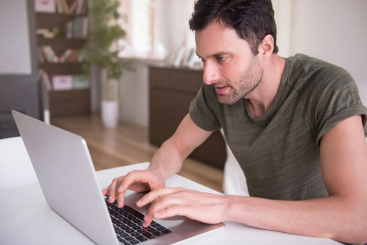 persona escribiendo en un computador portatil